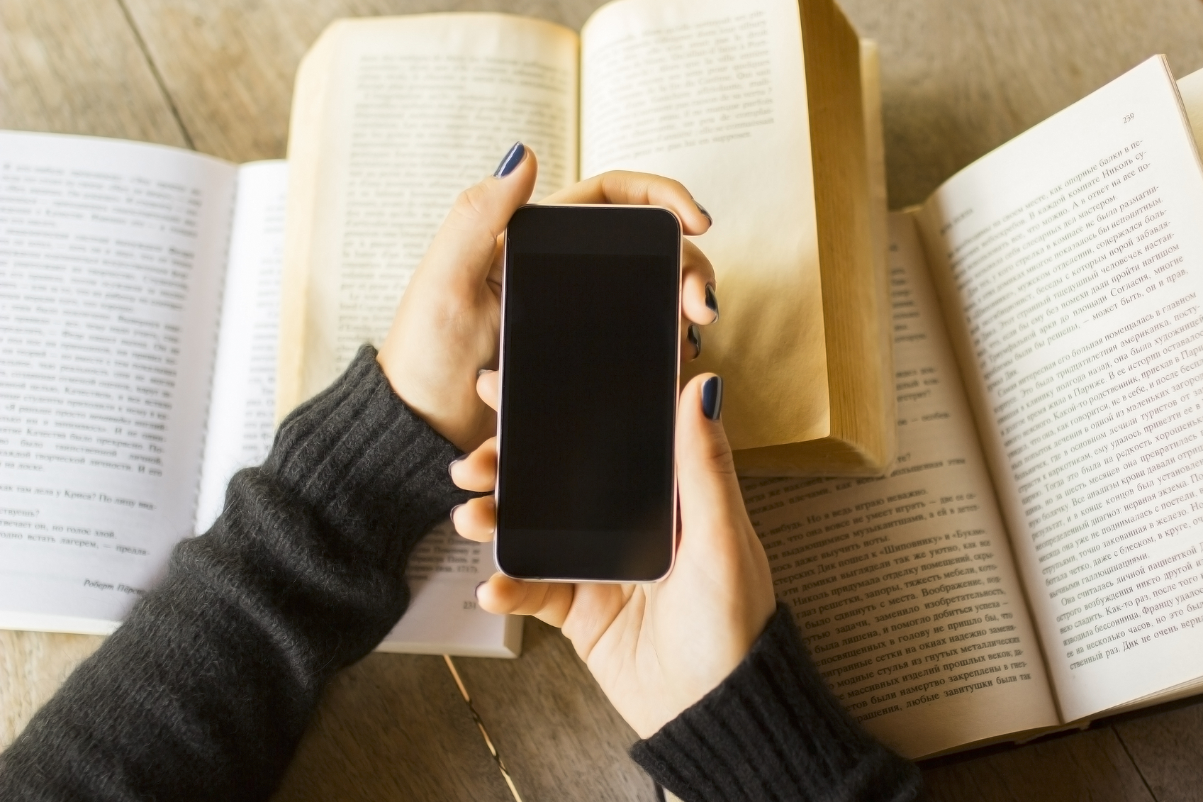 Girl with cell phone and books