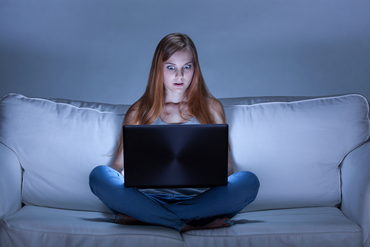Shocked girl using computer at night