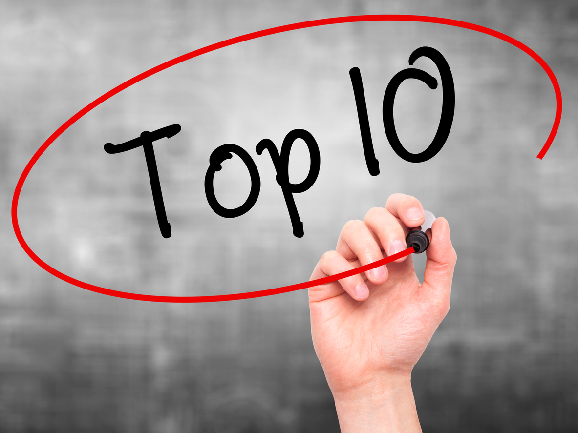 Hand writing Top 10 with marker on visual screen.