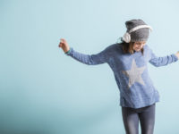 Girl with head phones dancing and listening to music