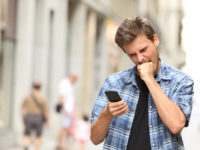 furious angry man watching mobile phone