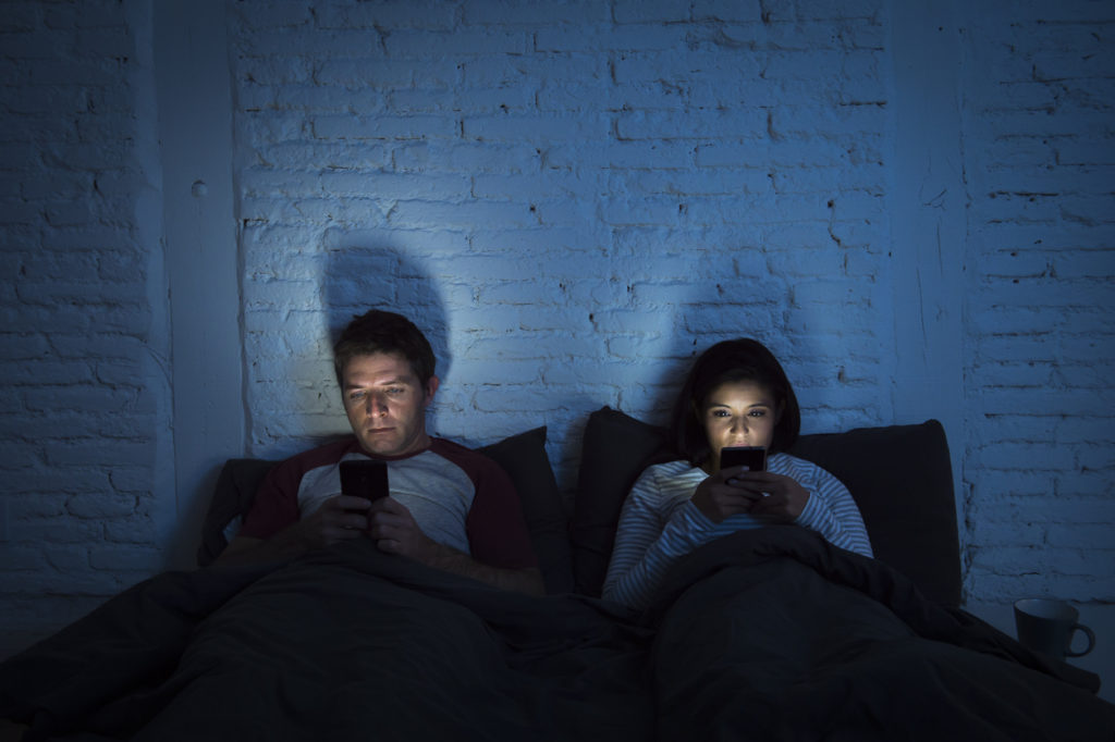 night couple in bed using mobile phone relationship communication problem