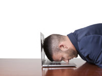 Businessman laying his head down on his laptop