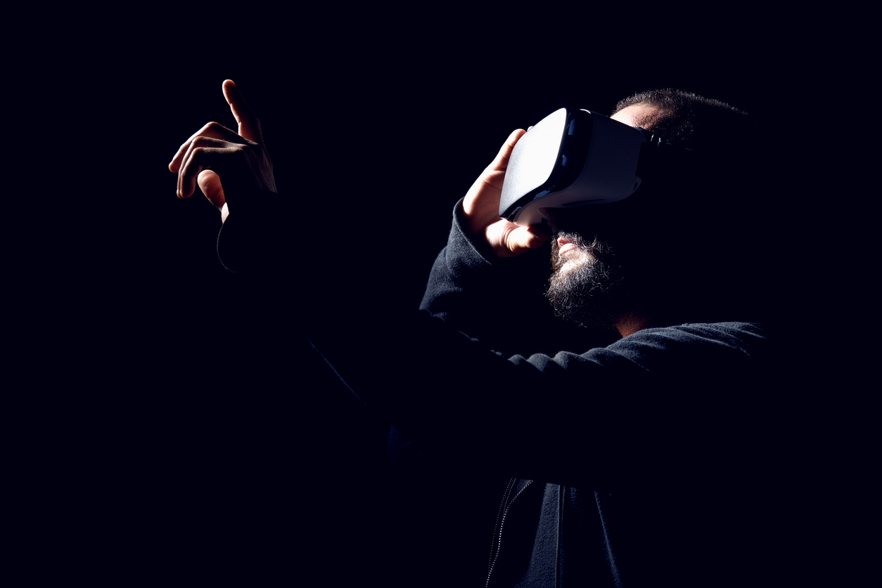 Hipster man wearing virtual reality goggles. Black background VR concept.