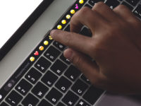 Close-up hand touching on touch bar on new macbook pro
