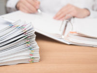 A pile of documents with the man in the document