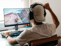 Teenager playing Fortnite video game on PC