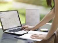 Woman planning agenda and schedule using calendar event planner. Woman hands using plan to vacation on computer laptop. Calender planner organization management remind concept.
