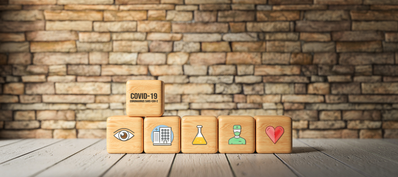 cubes with text COVID-19 and health icons in front of a brick wall - 3d rendered illustration
