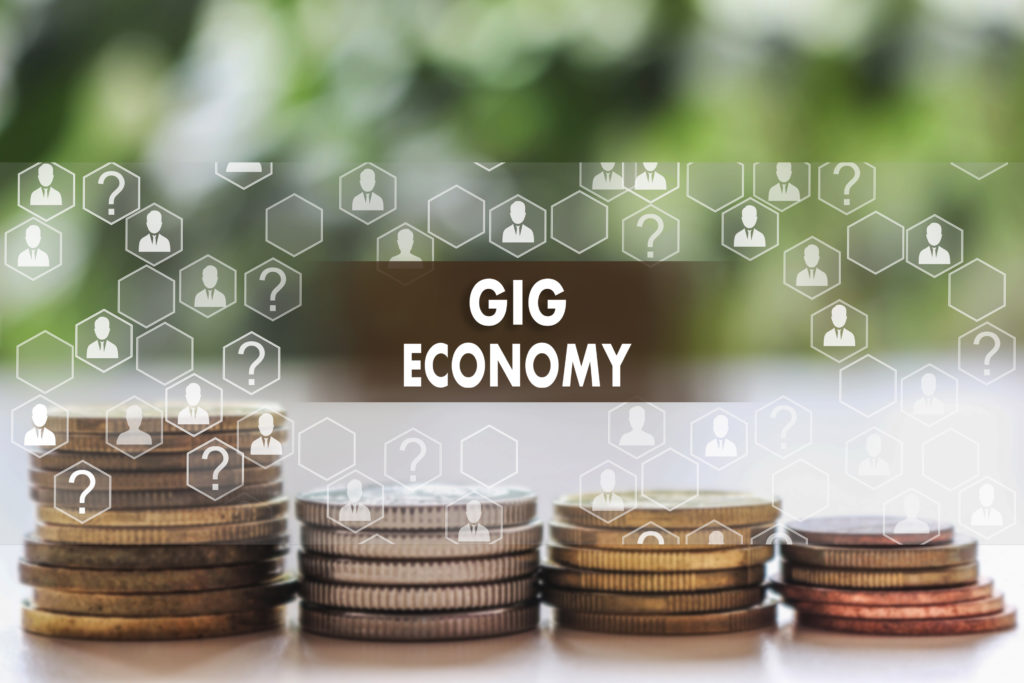 GIG ECONOMY on the touch screen with a  blur financial background .The concept GIG ECONOMY