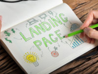 Human Hand Drawing Landing Page Concept On Notebook