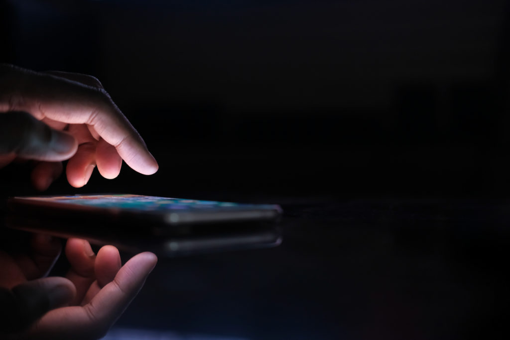 Close up of man hand use smart phone at night