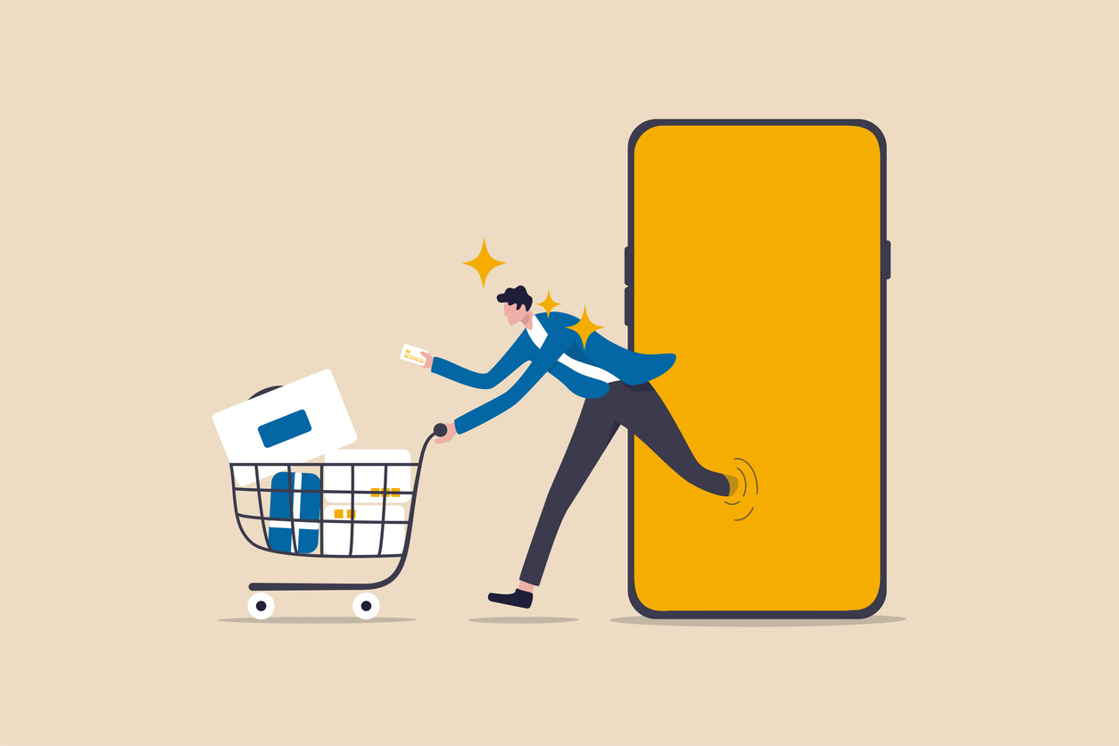 Online shopping or mobile shopping app concept, young man consumer holding credit cart pushing full of goods and box packages in shopping cart trolley running from website or app on mobile smart phone