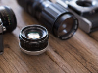Selective focus of Old film camera and lens on wooden background